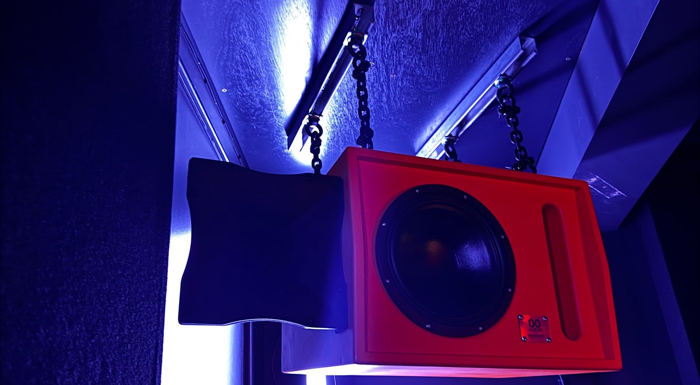 A custom red 00 Audio top flown against blue light at The Darkroom